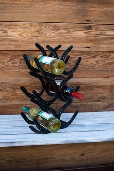 several bottles of wine are placed in the shape of a tree on top of a bench