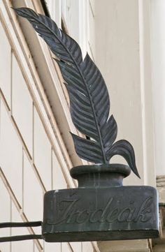 a sign on the side of a building that says coca - cola with a leaf