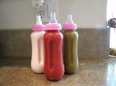 three baby bottles sitting on top of a counter