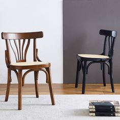 two wooden chairs sitting next to each other on top of a white carpeted floor