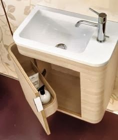 a white sink sitting under a bathroom mirror next to a wall mounted faucet