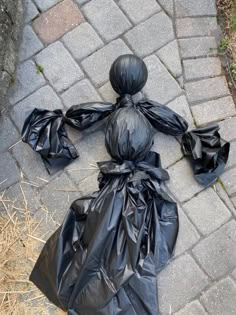 a black plastic bag sitting on top of a sidewalk