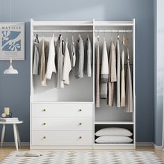 an open closet with clothes hanging on the rails and drawers, next to a white dresser