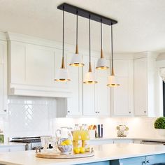 a kitchen with white cabinets and blue stools in front of an island countertop