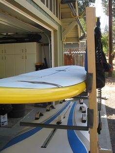 a surfboard is in the garage next to a storage area for other boards and equipment