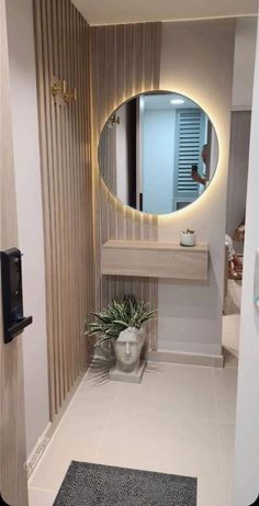 a bathroom with a round mirror above the sink and a potted plant on the counter