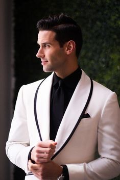 a man in a white suit and black tie