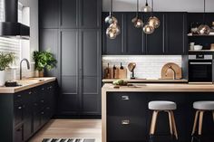 a kitchen with black cabinets and wooden counter tops, hanging lights over the island area