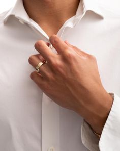 a man wearing a white shirt and gold ring