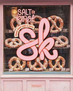 a store window with doughnuts in it and the words salt & kreme on display