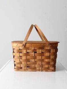 a wooden basket sitting on top of a white table