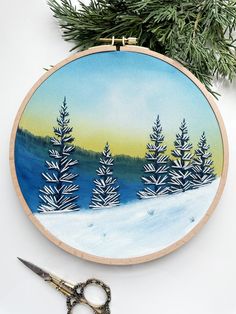 a cross - stitch pattern is being worked on by someone using scissors to make it look like they are in the snow