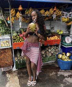 a woman standing in front of a fruit stand