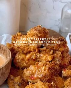 a plate topped with fried food next to a wooden bowl