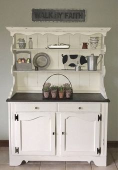 a white hutch filled with pots and pans