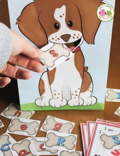 a person holding up a card with an image of a dog and letters on it