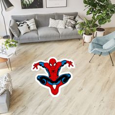 a living room filled with furniture and a spider man sticker on the floor