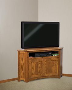 a flat screen tv sitting on top of a wooden entertainment center next to a wall