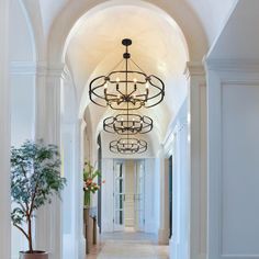 a hallway with an arched ceiling and chandelier hanging from it's sides