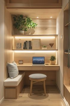 a desk with a laptop on top of it in front of a shelf filled with books and plants