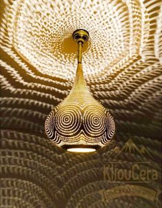 an artistic light fixture hanging from the ceiling in a room with circular patterns on it