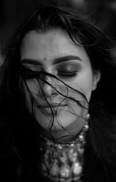 black and white photograph of a woman's face with her hair blowing in the wind