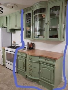 a kitchen with green cabinets and white appliances