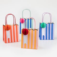 three bags with different colors and designs on them, one has a paper ball in the middle