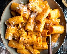 a bowl filled with pasta covered in sauce and parmesan cheese