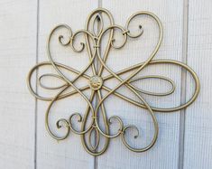 a metal wall hanging on the side of a white wooden door with an intricate design