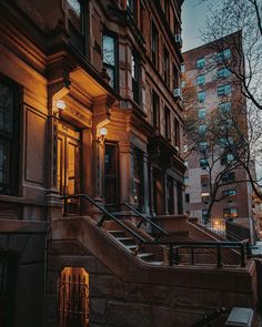 an apartment building with stairs leading up to the front door and windows on either side