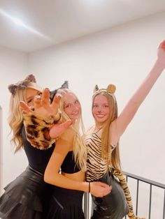 two girls dressed in costumes posing for the camera with their hands up and one girl wearing a cat costume