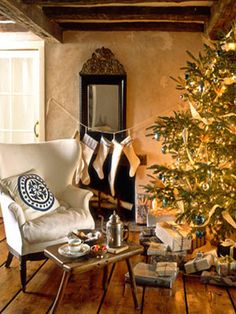 a living room with a christmas tree in the corner and presents on the floor next to it