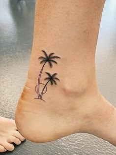 a woman's foot with a palm tree tattoo on her left side and right leg