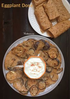 an eggplant dossaw is served on a plate with sour cream and crackers