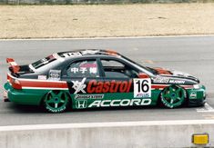 a green and red car driving down a race track