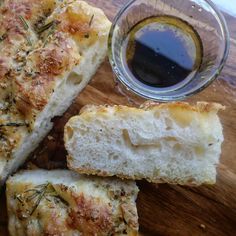 sliced bread with herbs on it next to a glass of olive oil