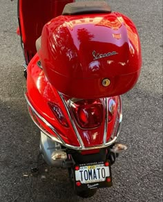 a red scooter is parked on the street