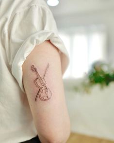 a woman with a violin tattoo on her arm