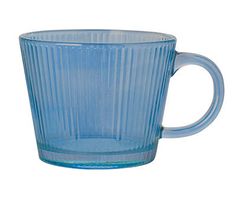 a blue glass cup sitting on top of a white table