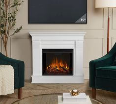 a living room with two chairs and a television on the wall above fire place in fireplace