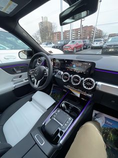 the interior of a car with dashboard, steering wheel and dash lights in front of other cars