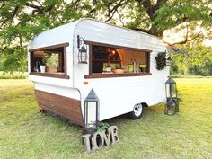 an old camper converted into a mobile home with the word love spelled out in front