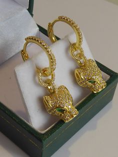 A fine pair of solid silver & gold plated art deco inspired panther head drop earrings. the heads are fully set with clear cubic zirconia's which sparkle like real diamonds .the eyes are set with two green zirconia's. each panther head is mounted on a silver/gold plated cubic zirconia set hoop which can be worn without panther heads so two earrings in one  .have a lovely fluid movement when worn. measure 3.1cm long x 1cm wide. stamped 925. look stunning when worn. Cat Hoop Earrings, Panther Head, Fluid Movement, Gold Art Deco, Plate Art, Gold Art, Art Deco Inspired, Real Diamonds, Panther