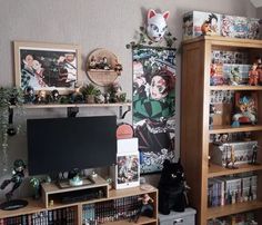 a living room filled with lots of books and furniture next to a wall covered in anime posters