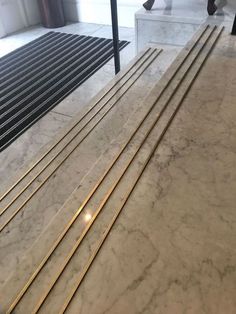 the marble floor is lined with gold bars and people are walking past it in the background