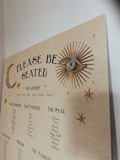 a sign that says please be seated with an eye in the center and stars around it