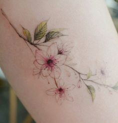 a close up of a person's leg with flowers on the side and leaves