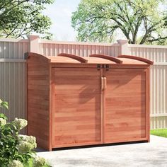 a large wooden storage shed next to a fence