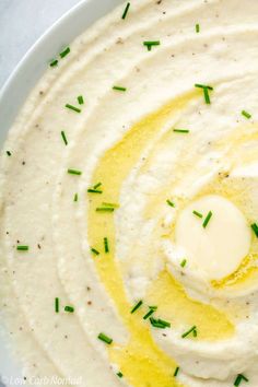 a white plate topped with hummus and green sprinkles